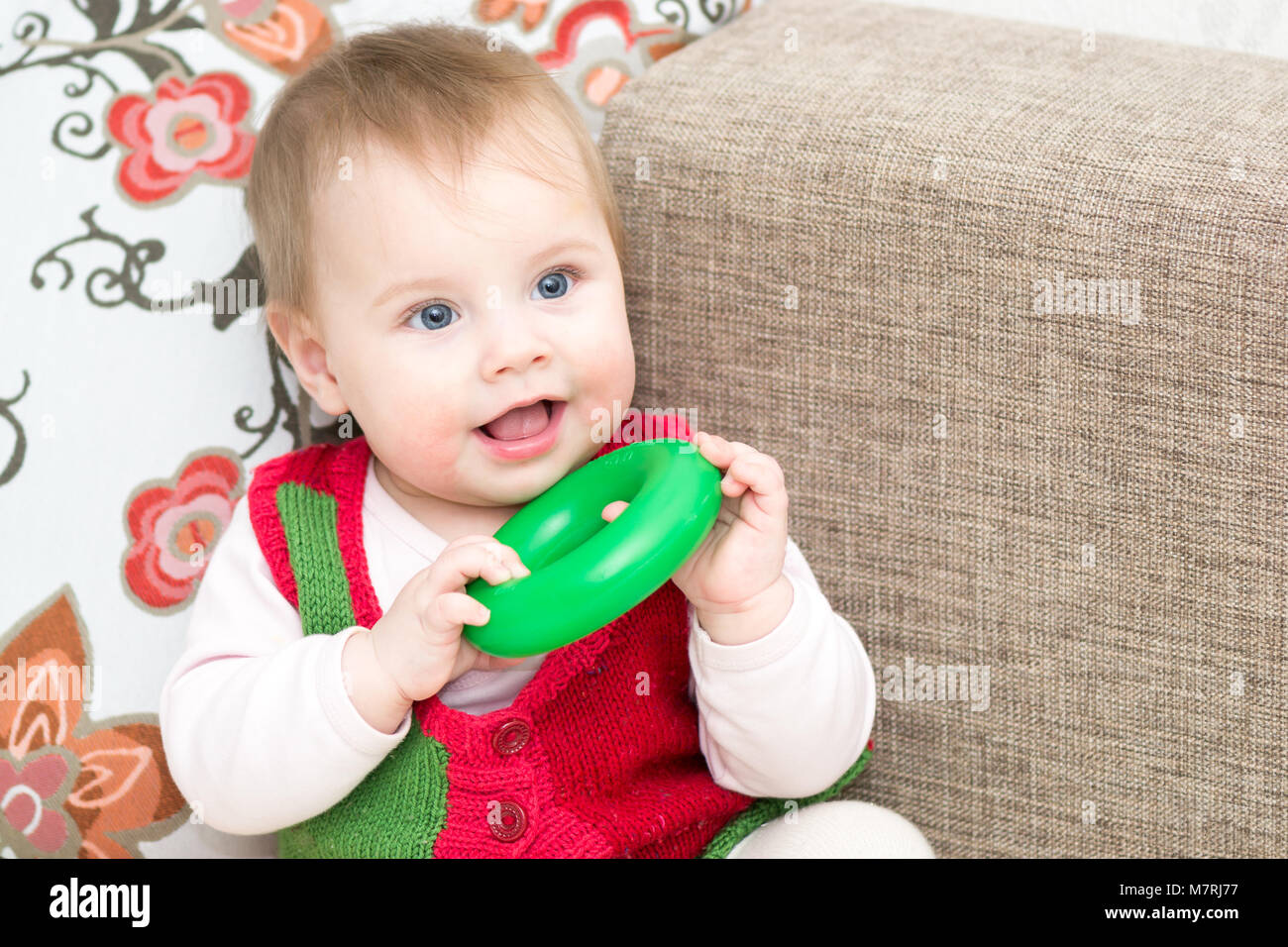 8 months old baby girl playing with pyramid ring Stock Photo