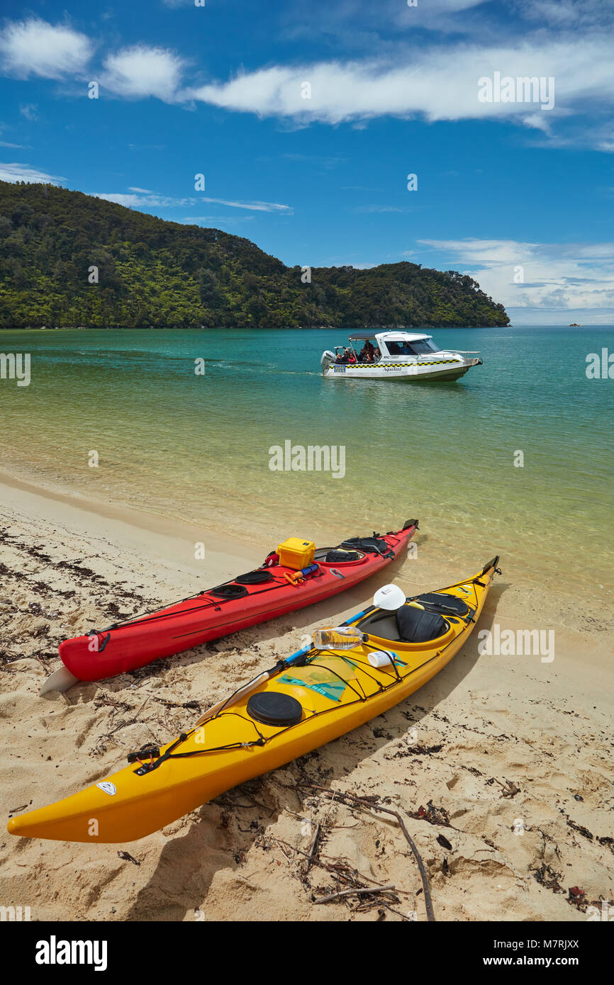 Kayaks and water taxi, Bark Bay, Abel Tasman National Park, Nelson Region, South Island, New Zealand Stock Photo