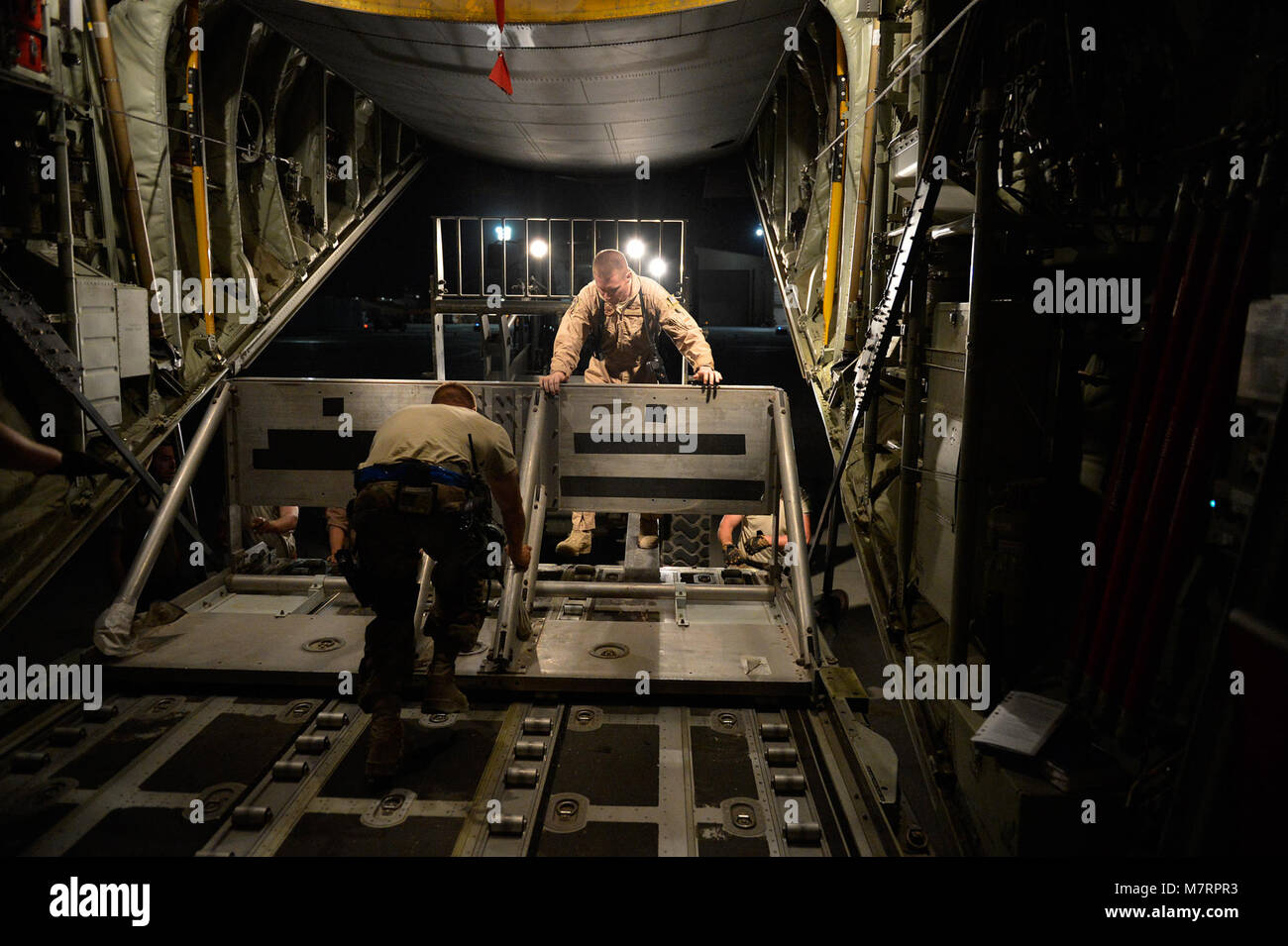 U.S. Airmen from the 774th Expeditionary Airlifit Squadron push equipment into a C-130J Super Hercules before an airdrop at Bagram Airfield, Afghanistan Aug. 1, 2014. The squadron completed an airdrop for the Afghan National Army using the new Wireless Gate Release System. (U.S. Air Force photo by Staff Sgt. Evelyn Chavez/Released) 455th Air Expeditionary Wing Bagram Airfield, Afghanistan Stock Photo