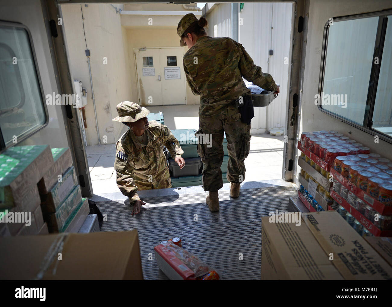 (From left) U.S. Air Force Master Sgt. Janet Budzinack, 455th Expeditionary Medical Support Squadron nutritional medicine flight chief and Staff Sgt. Dawn Spence, , 455th EMSS nutritional medicine diet technician unload meals off a truck for patients at Craig Joint Theater Hospital May 13 at Bagram Airfield, Afghanistan.  As part of nutritional medicine, they provide nutritional care and quality foodservice while promoting military readiness and community wellness. Budzinack is deployed from Wright-Patterson Air Force Base, Ohio and a native of Fontana, Calif. Spence is deployed from Lackland  Stock Photo