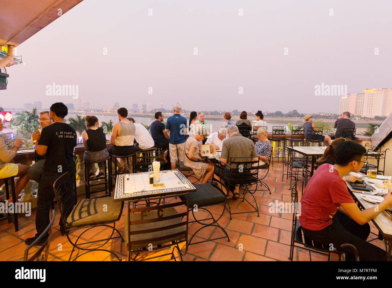 people sitting in the FCC ( Foreign Correspondents' Club ) overlooking the Mekong River, Phnom Penh, Cambodia Asia Stock Photo