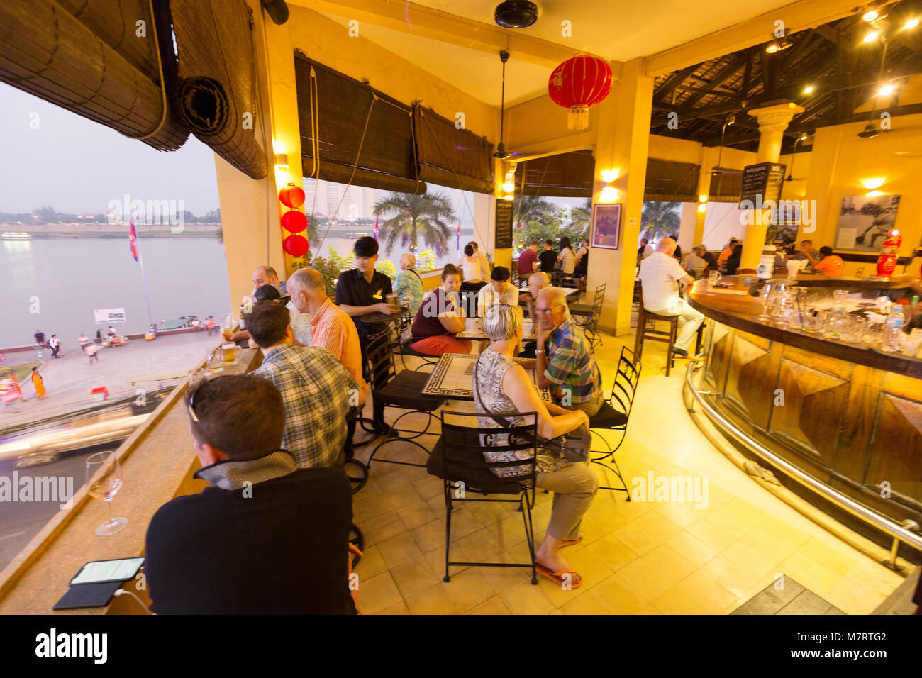 people sitting in the FCC ( Foreign Correspondents' Club ) overlooking the Mekong River, Phnom Penh, Cambodia Asia Stock Photo