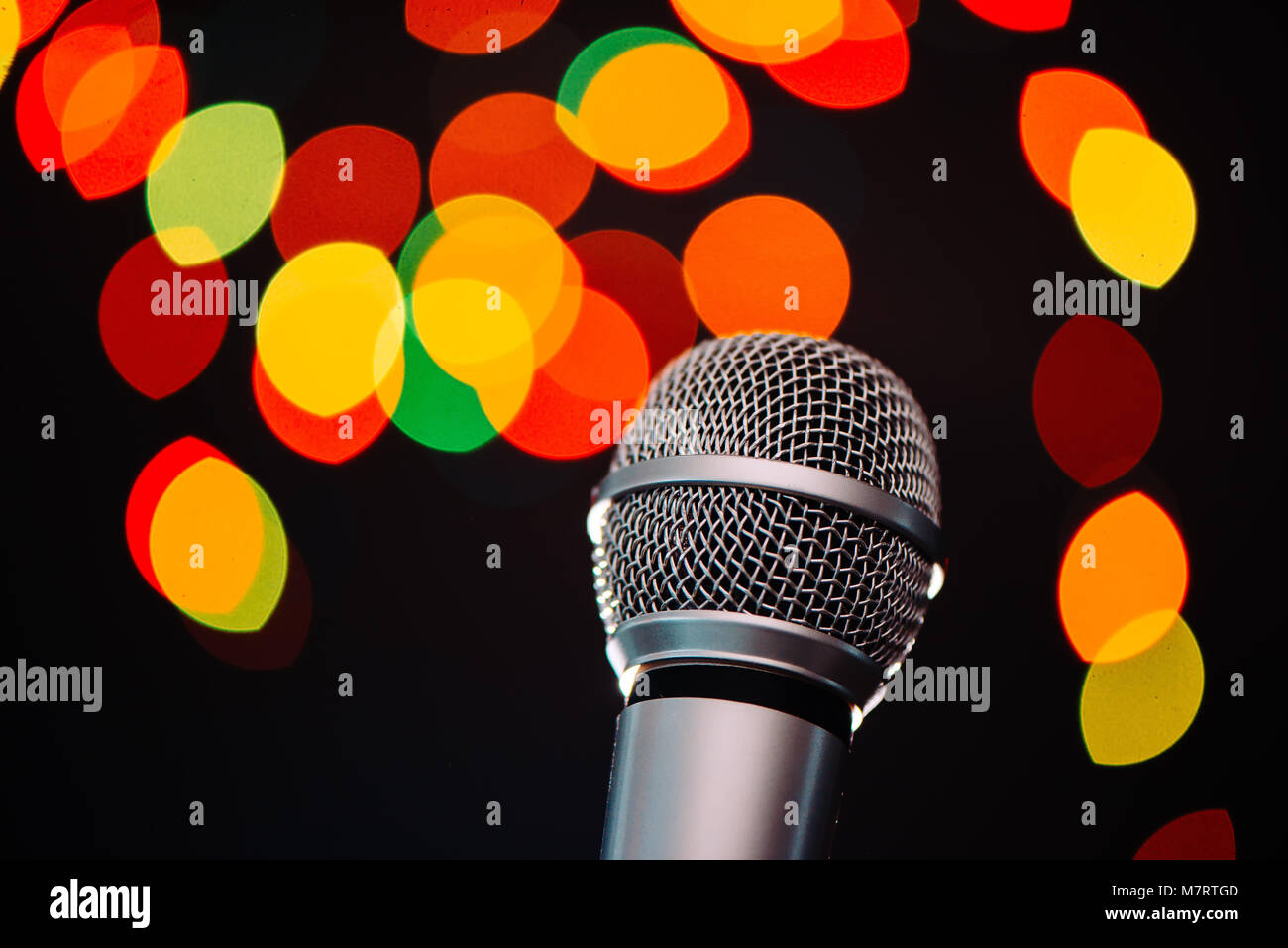Audio microphone in karaoke bar with festive bokeh light background Stock Photo