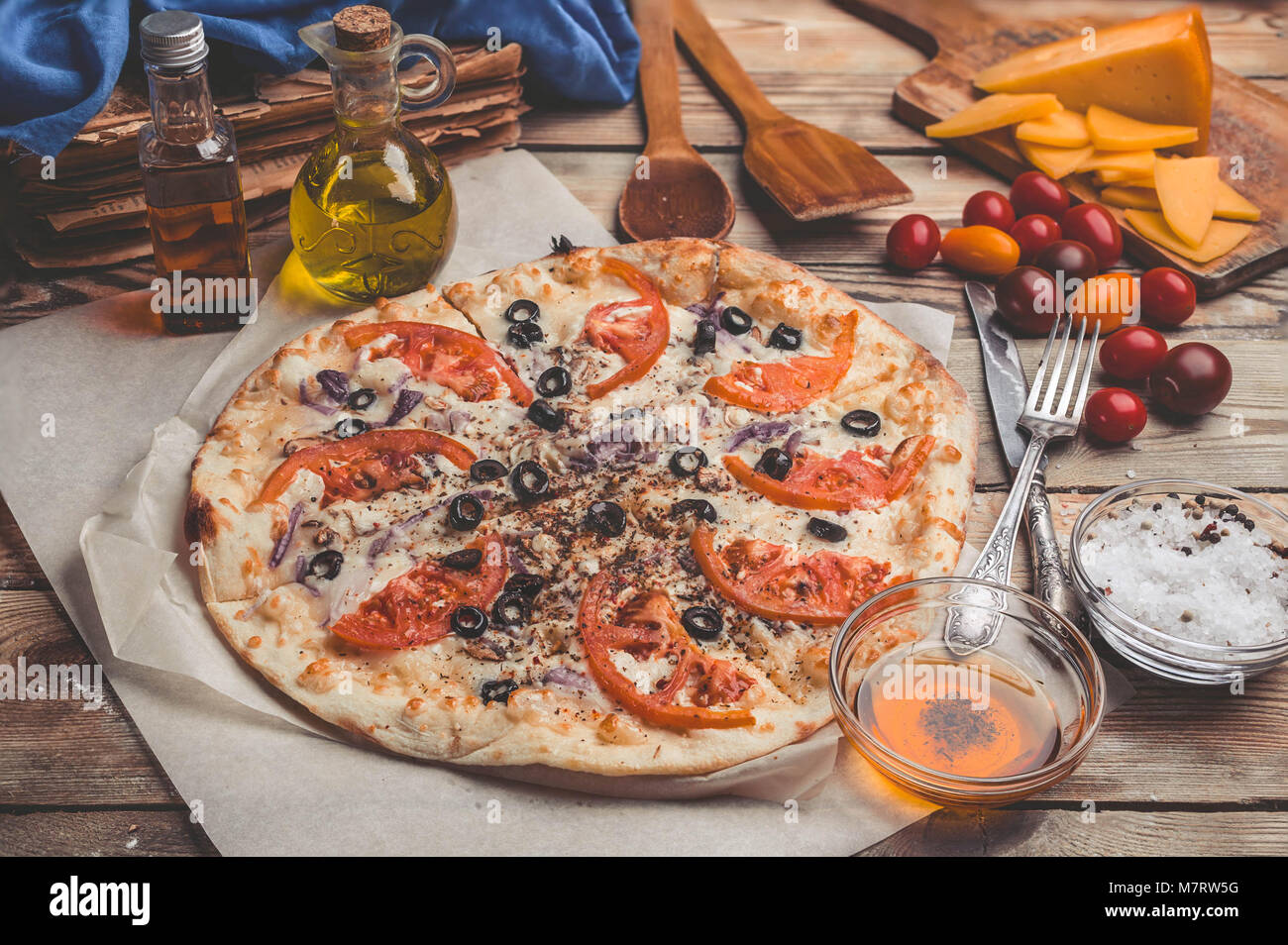 Pizza Margarita on thin crust. Food composition on a wooden background. Mediterranean traditional cuisine. Easy vintage toning Stock Photo