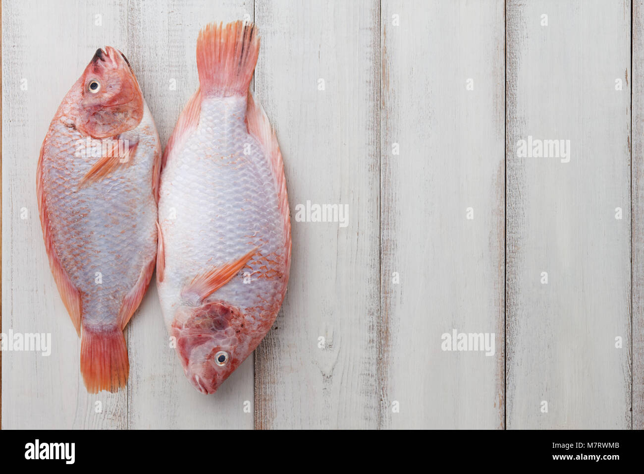 Peeled red tilapia on white wooden boards Stock Photo