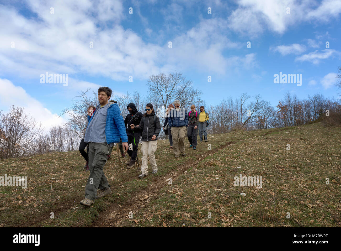 Monte San Giovanni in Sabina, Italy - March 10, 2018: A group of hikers explore mountain paths, among oak and holm oak woods. Stock Photo