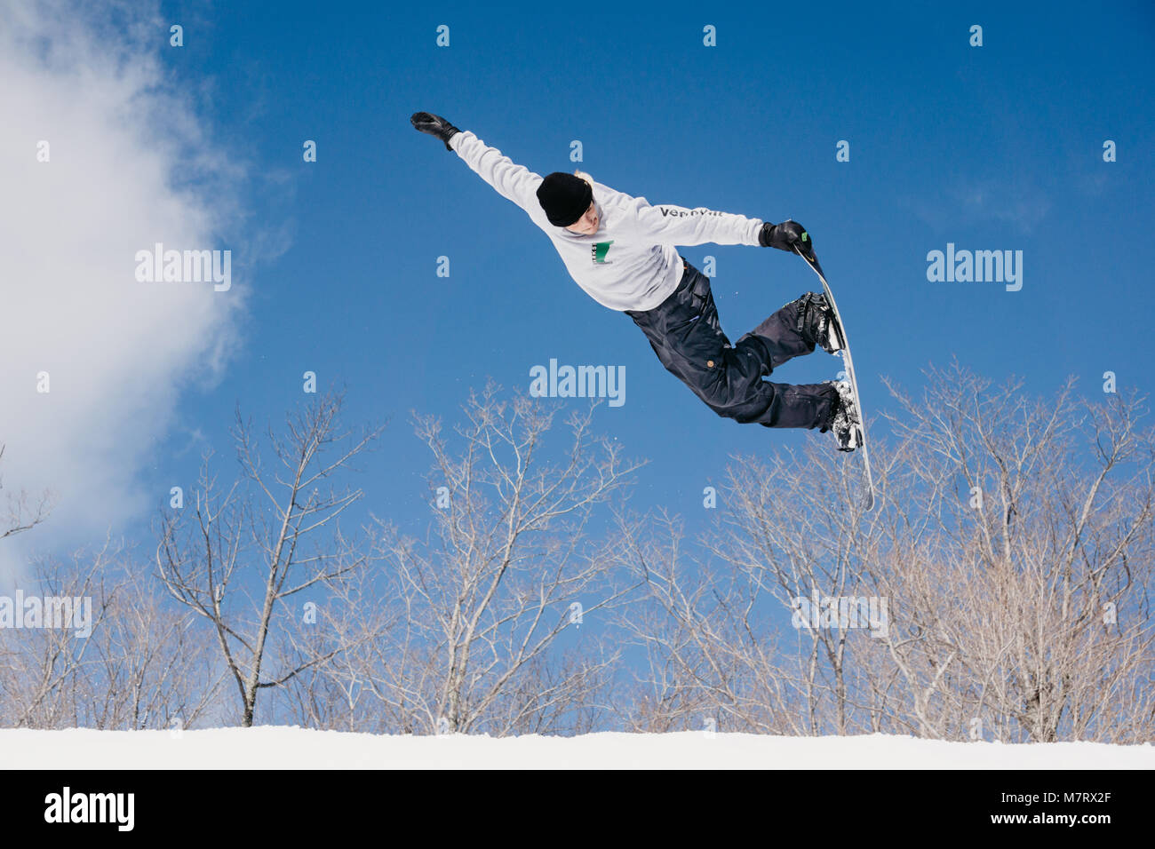 Snowboarder jumping with board grab Stock Photo