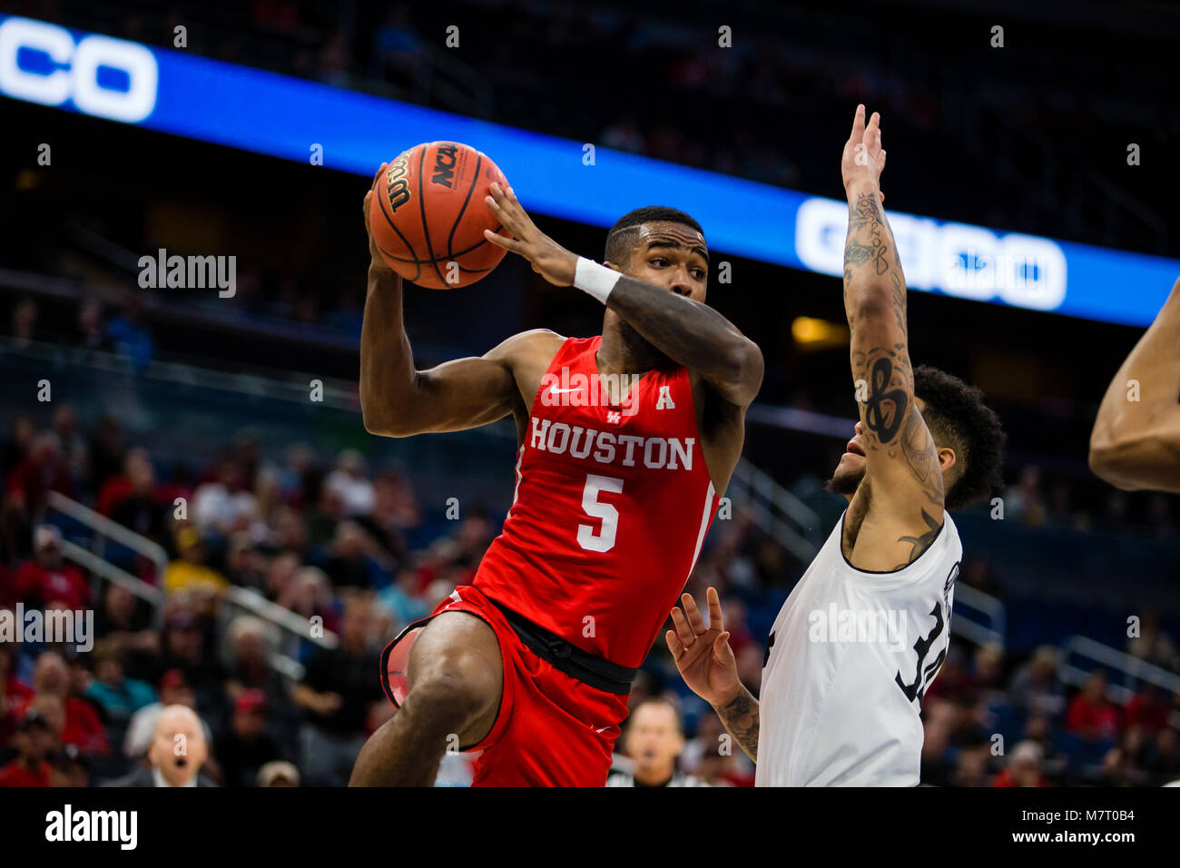 Houston guard Corey Davis Jr attempts to pass the ball against Cincinnati defender Jarron Cumberland in the American Athletic Conference Championship. Stock Photo