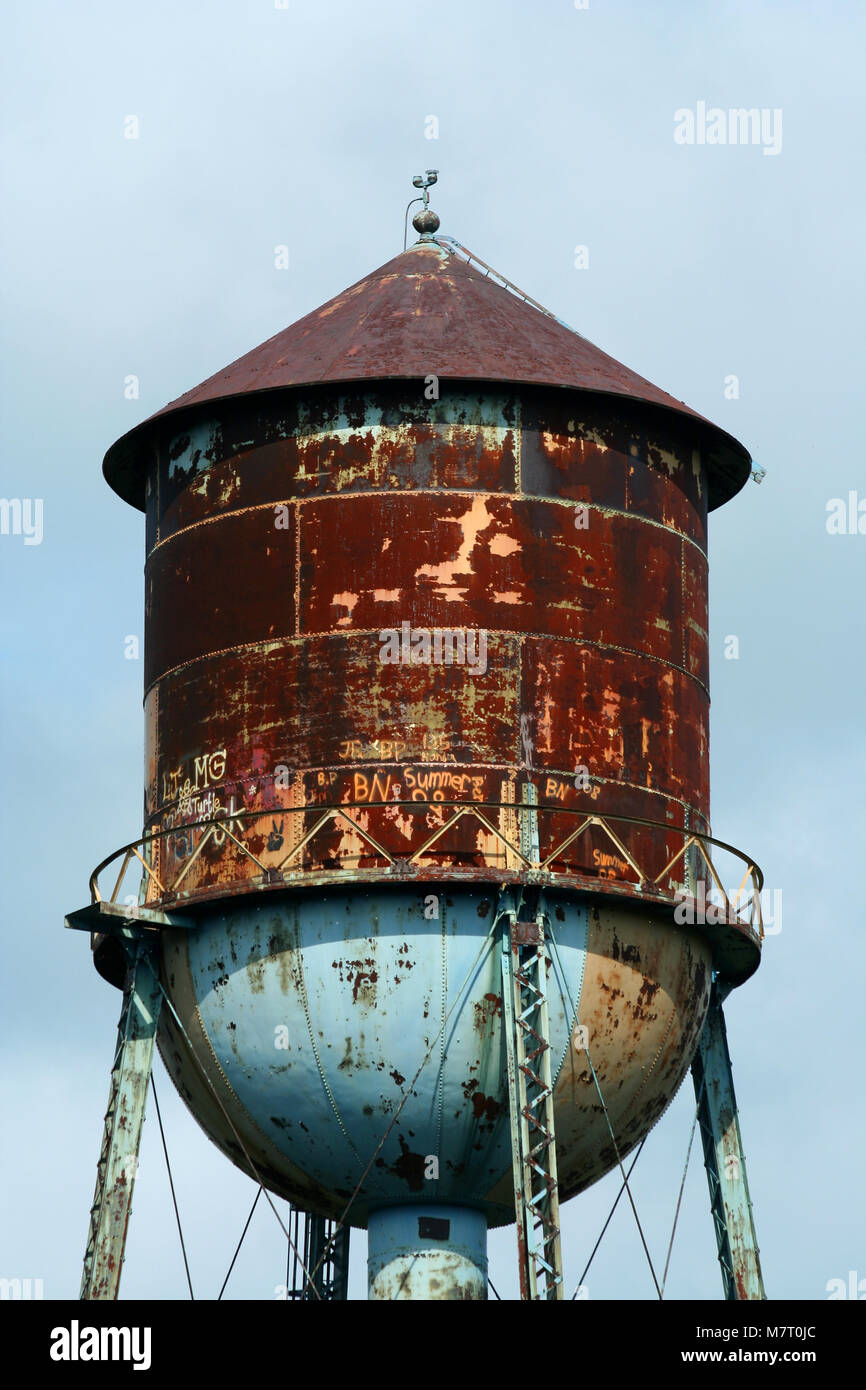 A Old rusty watertower against blue sky Stock Photo - Alamy