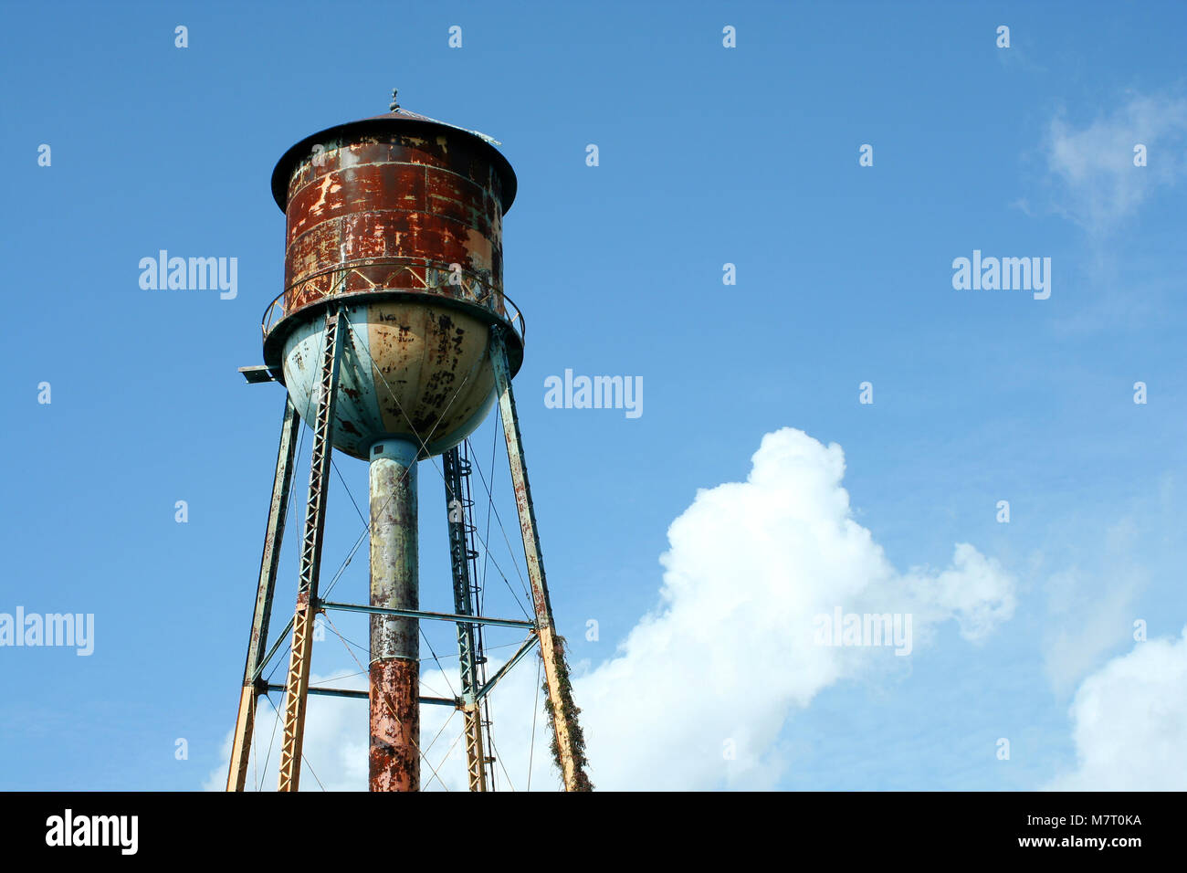 A Old rusty watertower against blue sky Stock Photo - Alamy