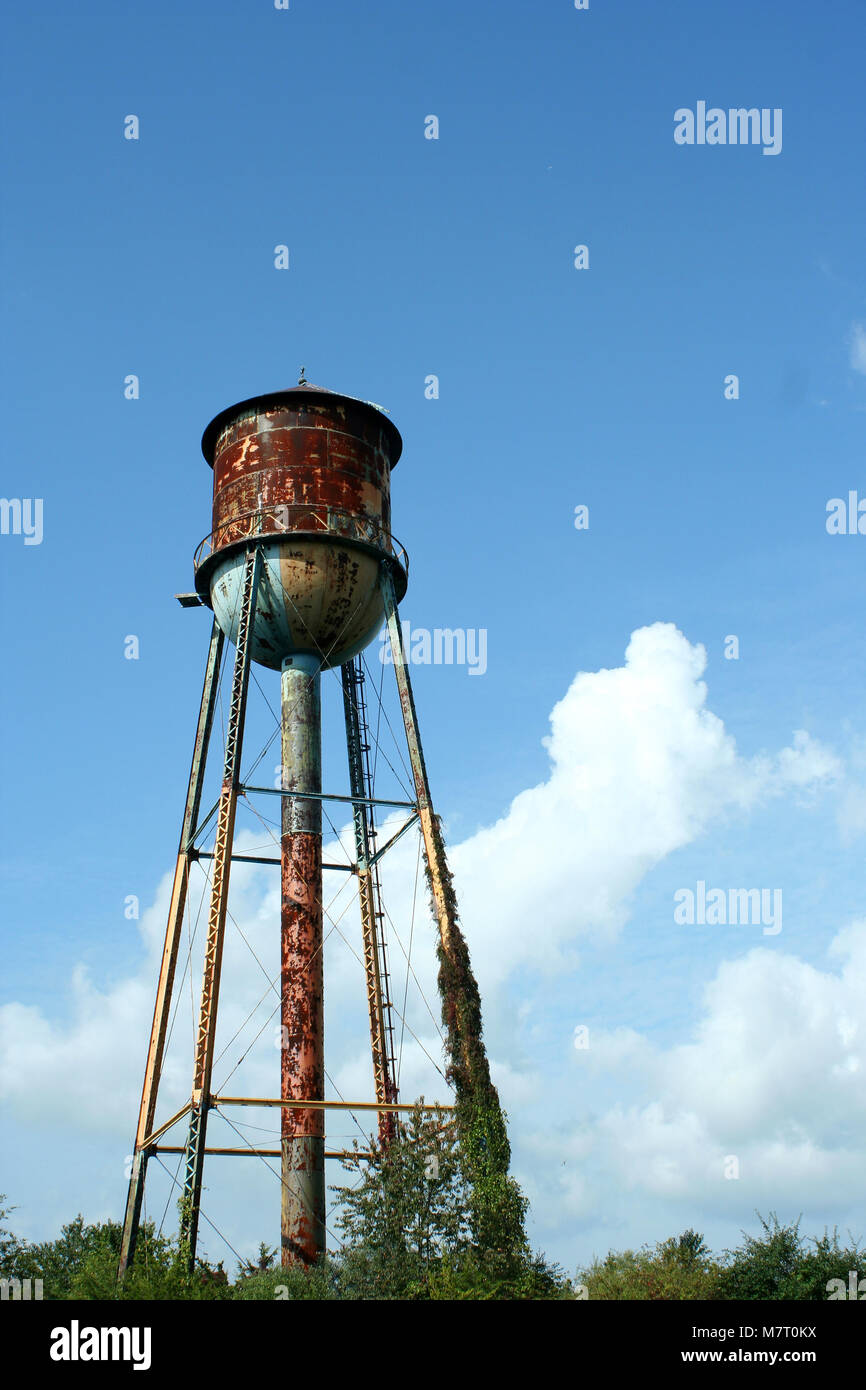 A Old rusty watertower against blue sky Stock Photo - Alamy
