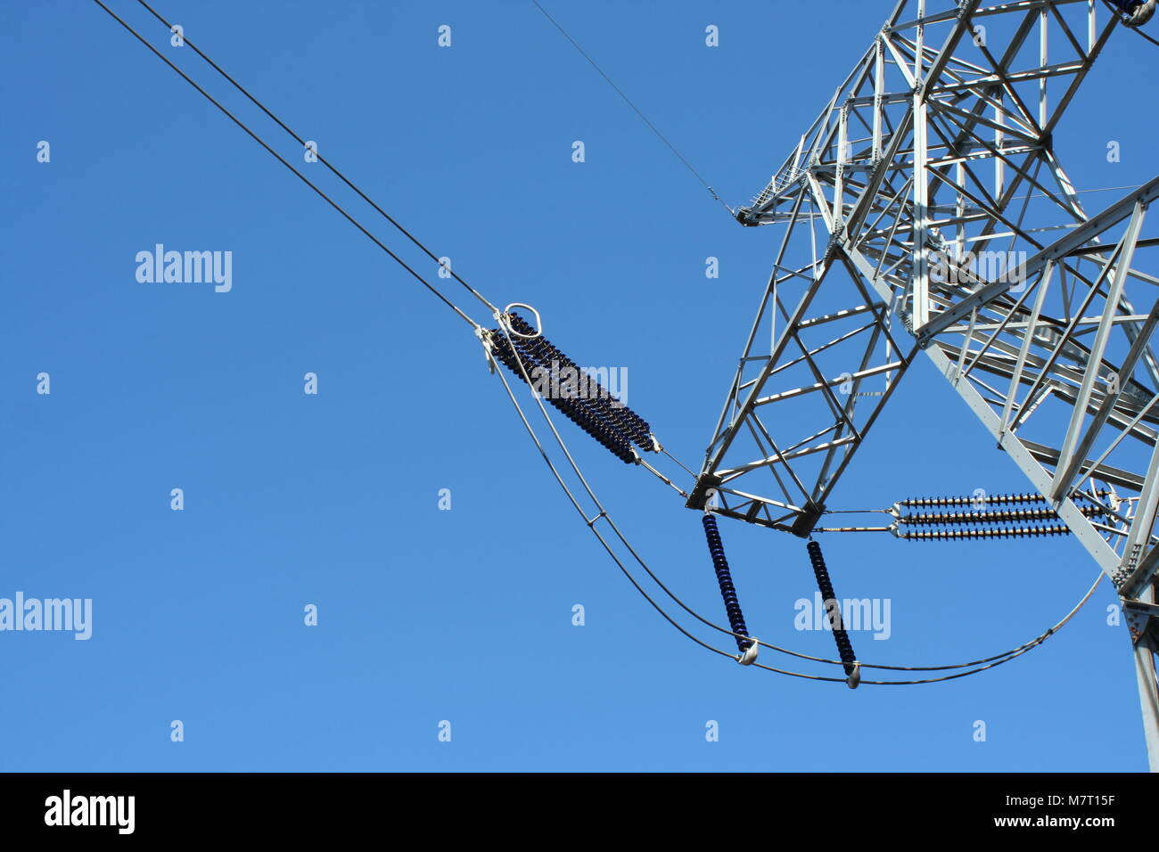 Power line tower against blue sky Stock Photo - Alamy