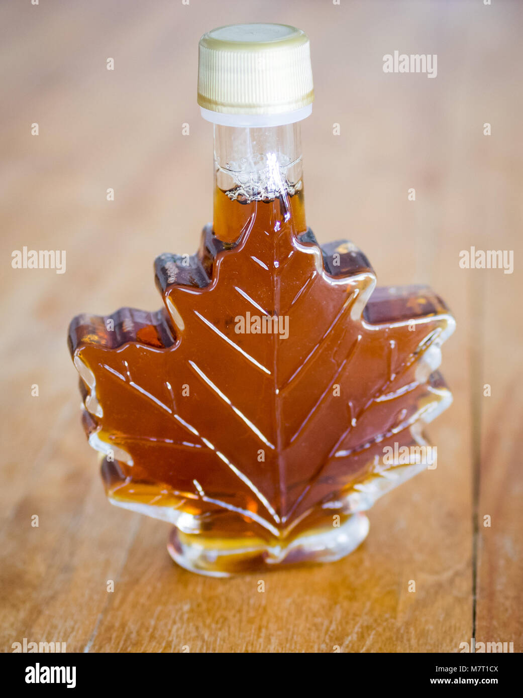 Real Canadian maple syrup in a glass maple syrup bottle. Stock Photo
