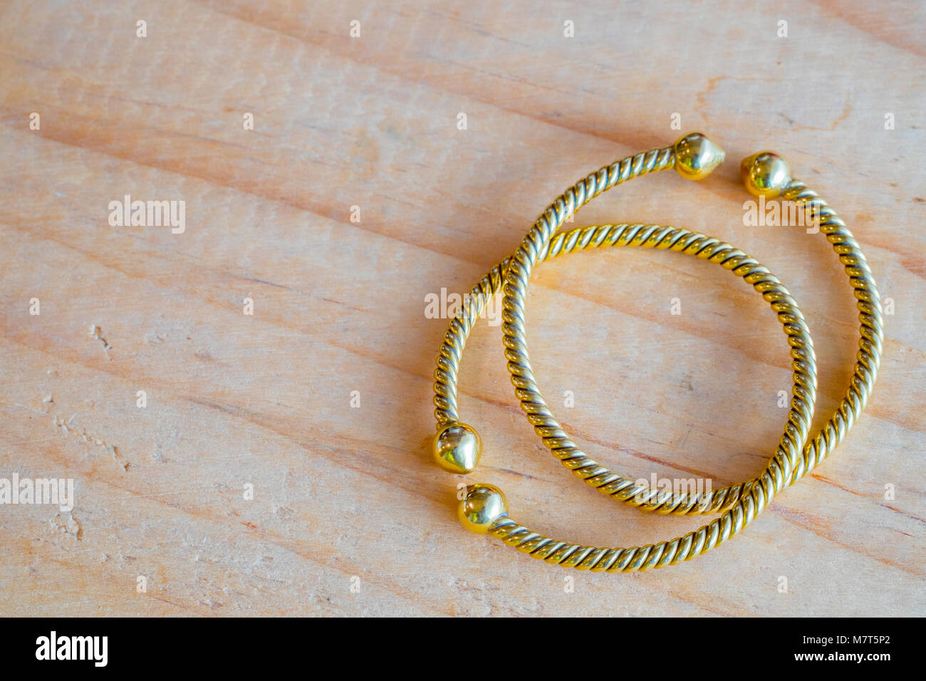 Gold bracelets on wooden table. It's jewelry and fashion for ladies Stock  Photo - Alamy