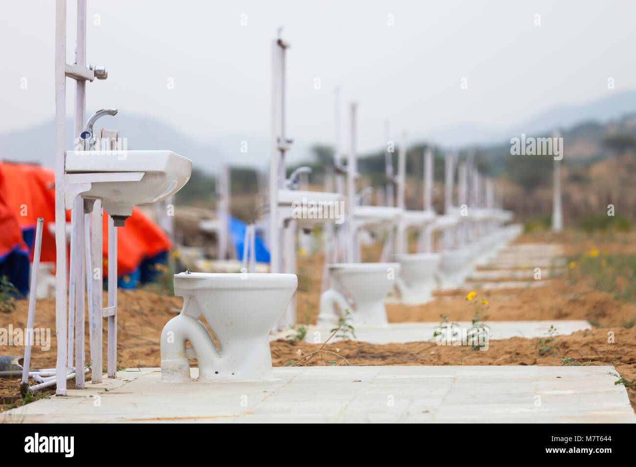 A line of basins and toilets in a field near the Pushkar Camel Fair, Rajasthan which will be covered by tents providing accommodation for visitors Stock Photo