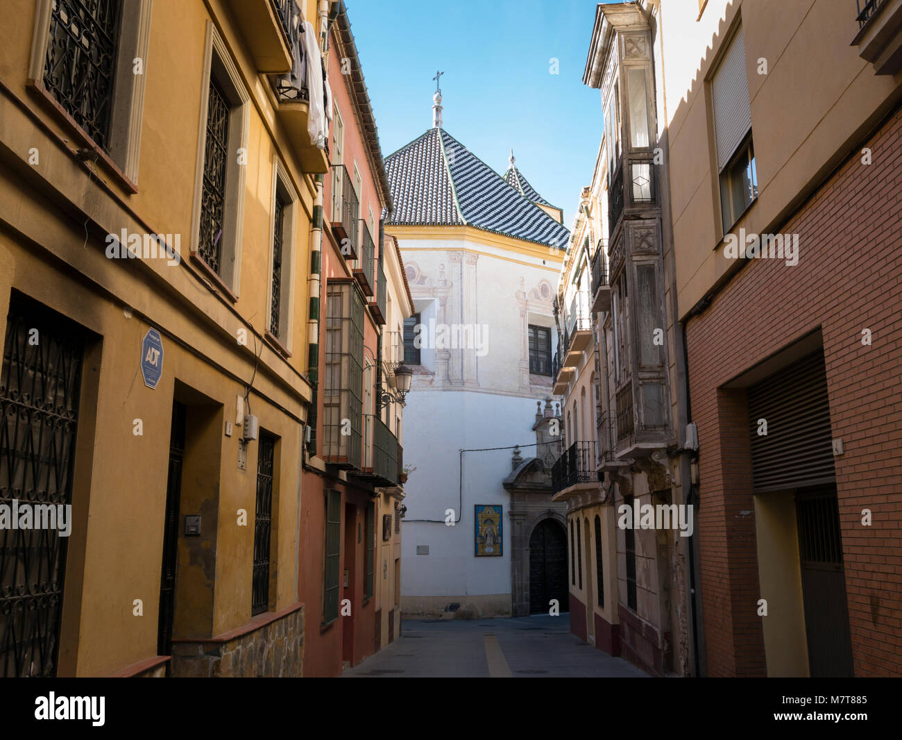 Narrow street and the Church of San Felipe Neri in the old town, Malaga, Andalusia, Spain. Stock Photo