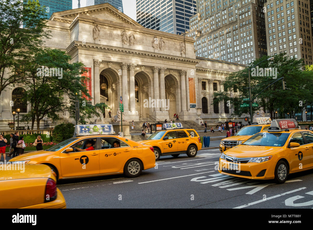 Yellow New York taxis driving past The New York Public Library on 5th Avenue , Manhattan ,New York City Stock Photo