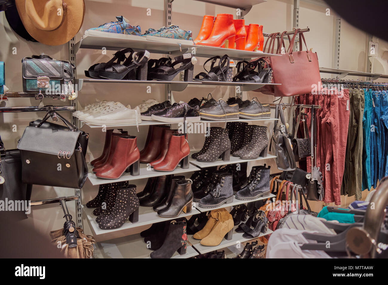 Bags, pants, shoes, sneakers and women's dress boots on shelves for sale in store of Toledo Stock Photo