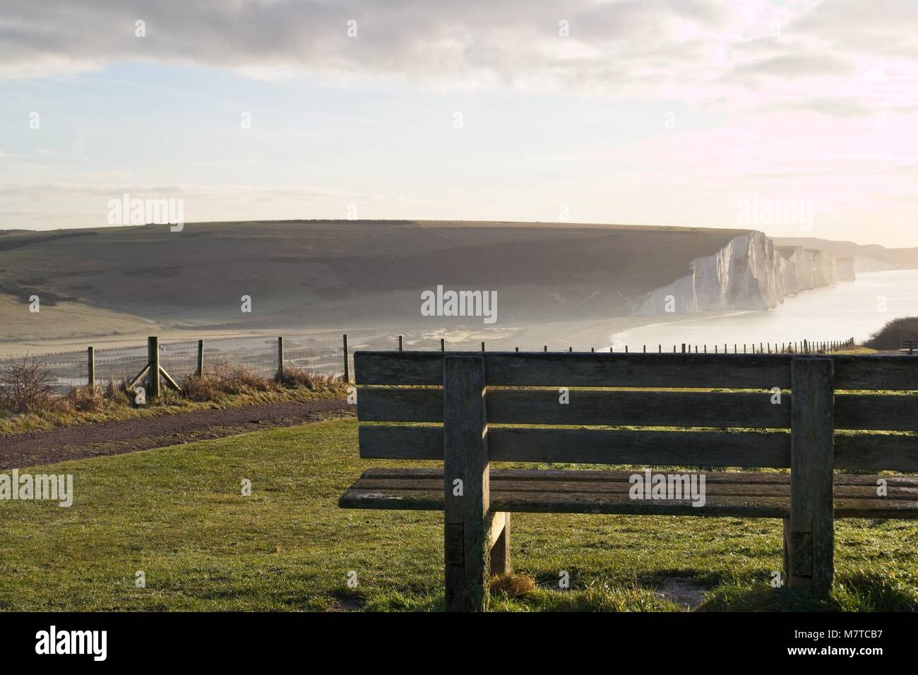 Wooden bench looking out over frosty morning view of Seven Sisters chalk cliffs Stock Photo