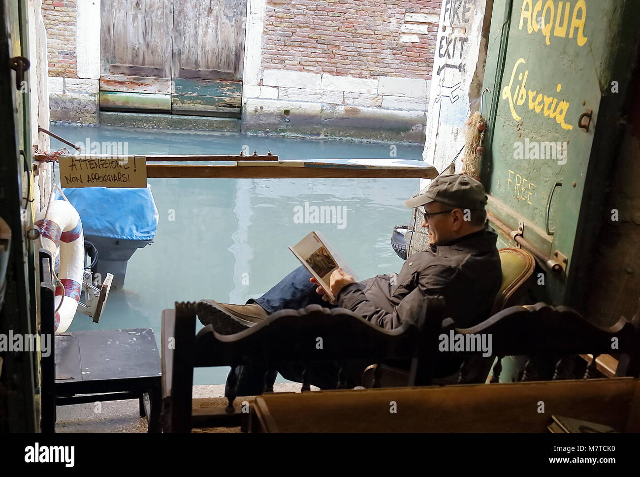 Venice, Italy - January 22, 2018. A tourist in Acqua Alta Libreria, most famous used bookstore in Venice. Stock Photo