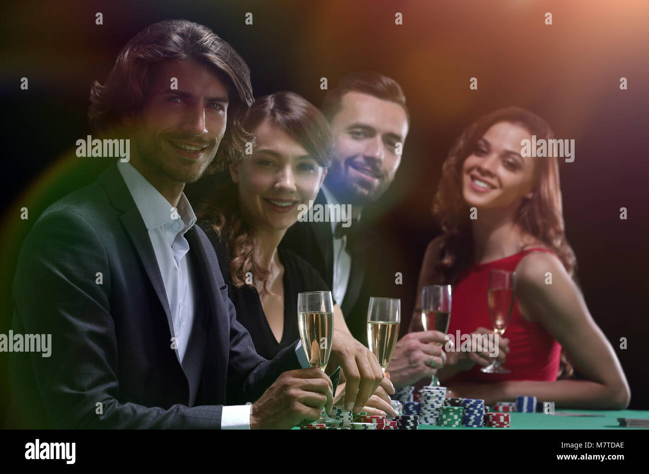 side view of group of people playing poker together in casino Stock Photo
