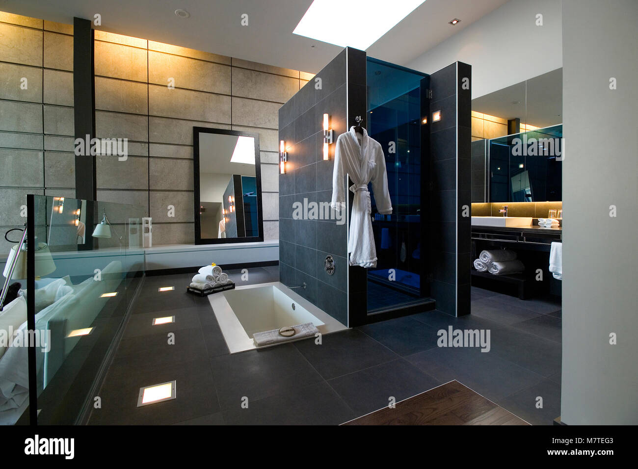 En suite bathroom with dark grey tiles. Bath and shower Stock Photo