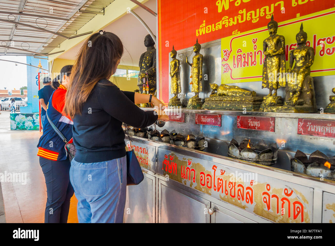 AYUTTHAYA, THAILAND, FEBRUARY, 08, 2018: Outdoor view of unidentified woman using candles at Wat Lokayasutharam in Ayutthaya Stock Photo