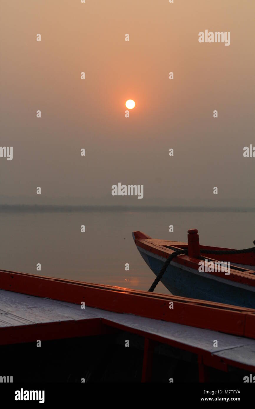 Sunset in the river with boats and people Stock Photo - Alamy