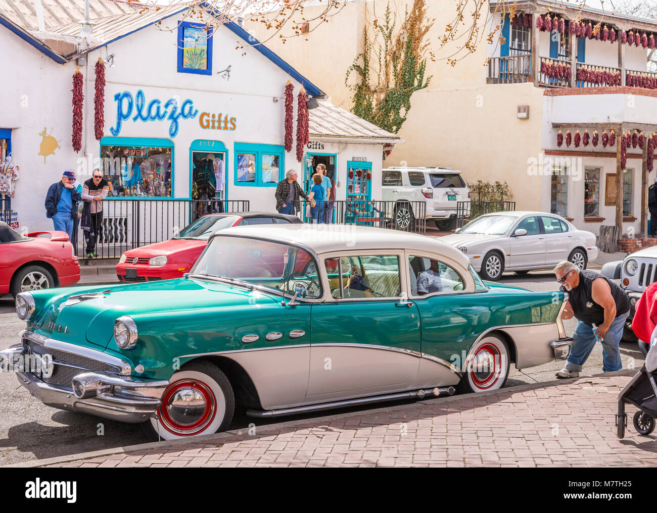 Man polishing, waxing 1956 Buick Special near tourist shops and shopping in Albuquerque Old Town Plaza, New Mexico USA. Stock Photo