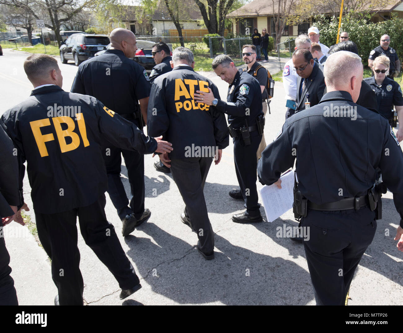 Agents from the FBI and Bureau of Alcohol, Tobacco and Firearms (ATF) walk  in a residential neighborhood in east Austin where a package bomb exploded  Monday, injuring an elderly Austin resident. The
