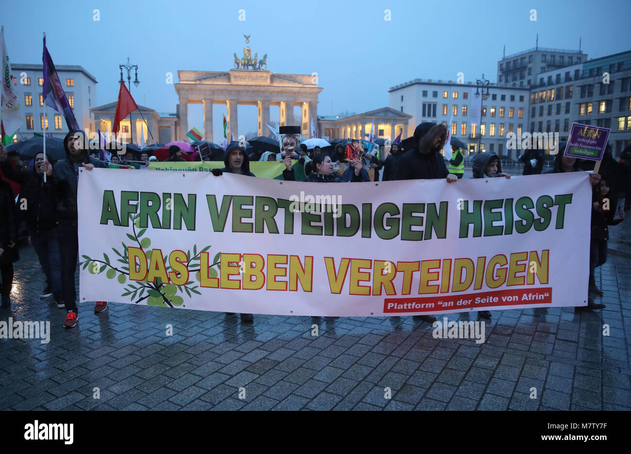 12 March 2018, Germany, Berlin: Some two hundred Kurs protest with a banner reading 'Afrin verteidigen heisst das Leben verteidigen' (lit. defending Afrin means defending life) against the Turkish military operation against Kurds in North Syria in front of the Brandenburg Gate. Photo: Jörg Carstensen/dpa Stock Photo