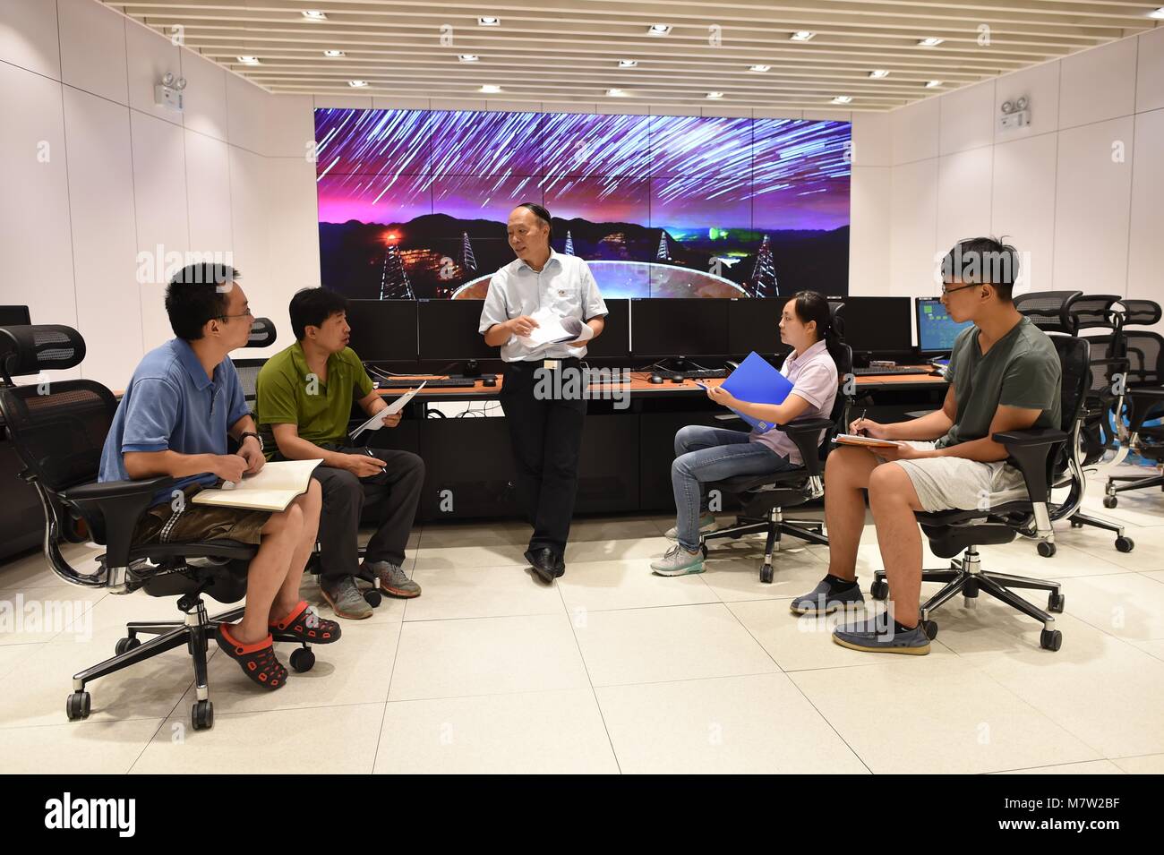 (180313) -- GUIYANG, March 13, 2018 (Xinhua) -- File photo taken on Aug. 10, 2017, shows staff members communicating in the control room of the Five-hundred-meter Aperture Spherical Radio Telescope (FAST) in Pingtang County, southwest China's Guizhou Province. China's FAST, the world's largest single-dish radio telescope, has discovered 11 new pulsars so far, the National Astronomical Observatories of China (NAOC) said Tuesday. (Xinhua/Ou Dongqu)(wsw) Stock Photo