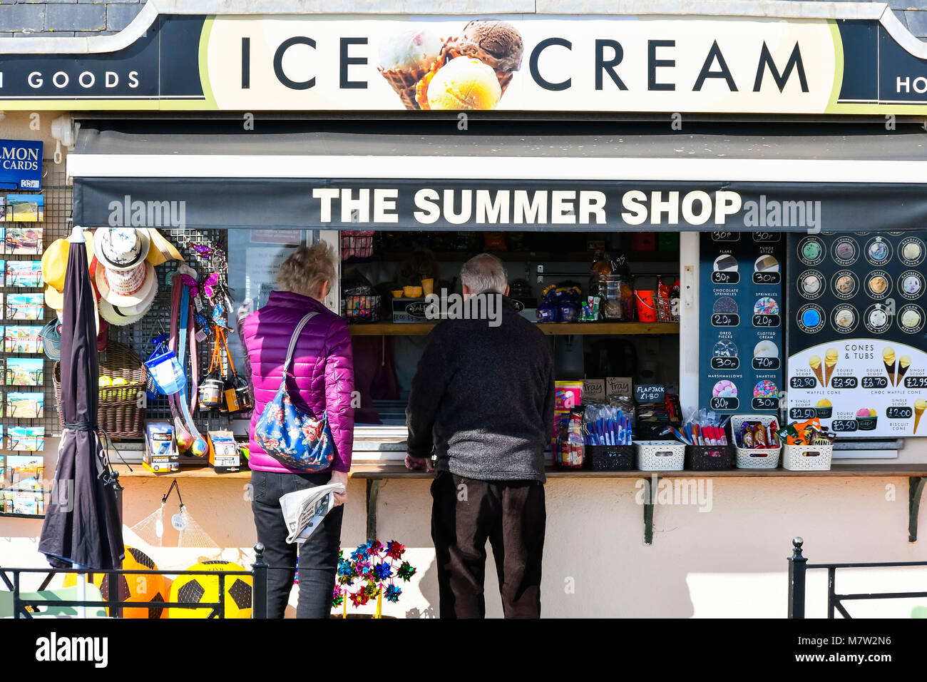 Sidmouth, Devon, UK.  13th March 2018.  UK Weather.  A couple buying an ice cream from The Summer Shop kiosk at the seaside town of Sidmouth in Devon on a warm sunny spring afternoon.  Picture Credit: Graham Hunt/Alamy Live News. Stock Photo