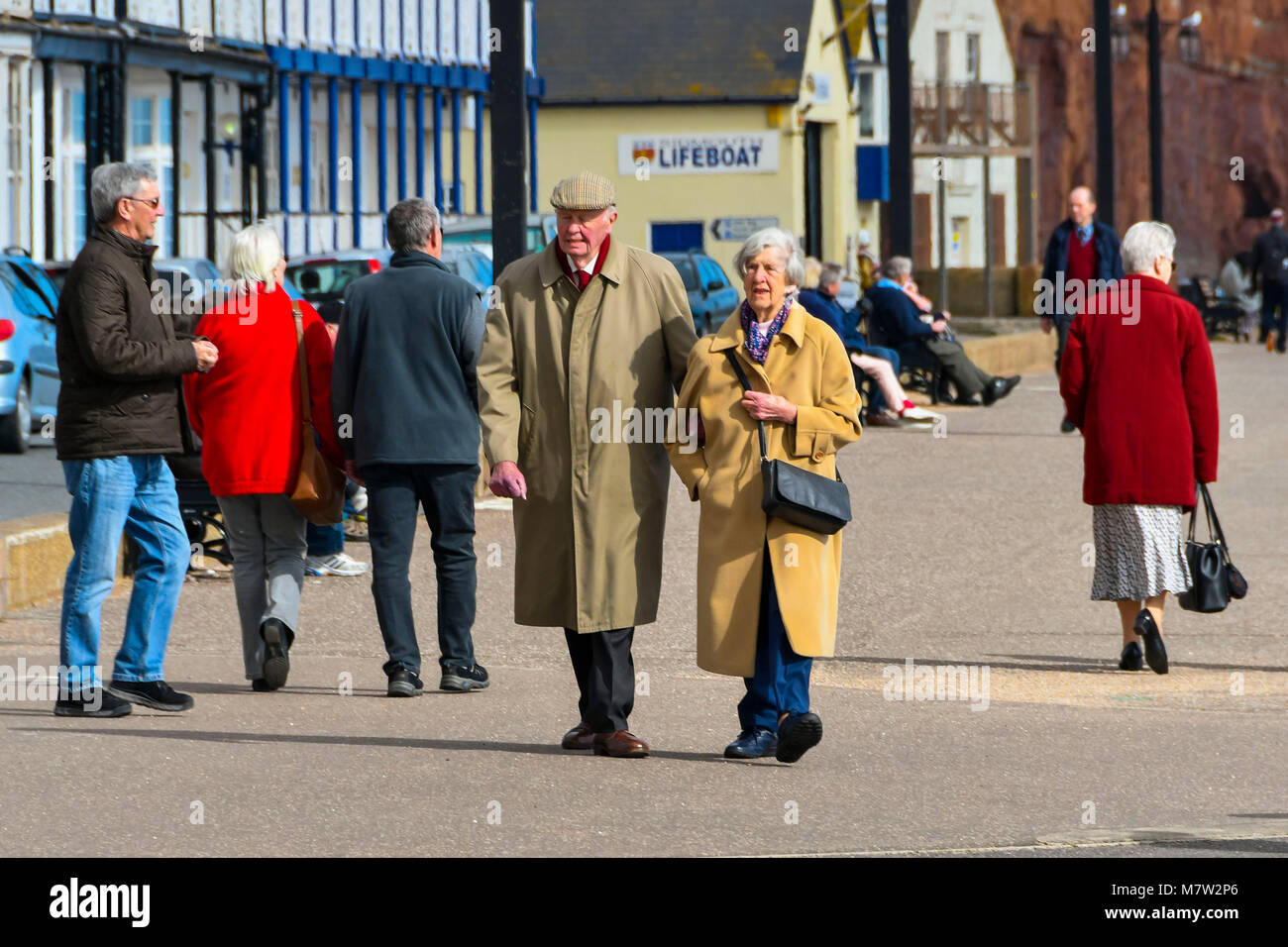 Sidmouth, Devon, UK.  13th March 2018.  UK Weather.  Visitors and residents enjoying a walk along the seafront at the seaside town of Sidmouth in Devon on a warm sunny spring afternoon.  Picture Credit: Graham Hunt/Alamy Live News. Stock Photo