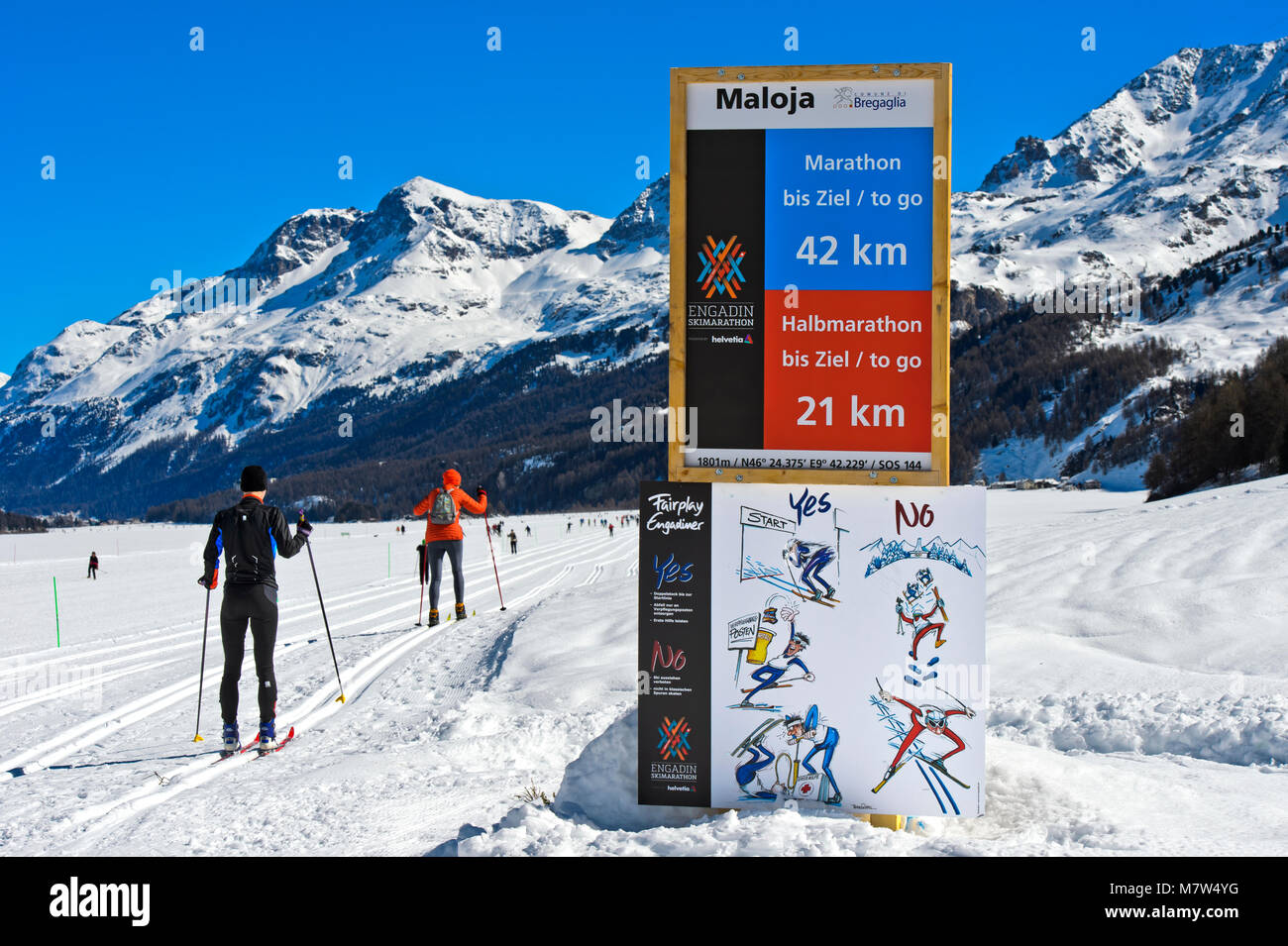 Signpost indicating distance to finish and fair-play rules at the Engadin Skimarathon, Maloja, Engadin, Grisons, Switzerland Stock Photo