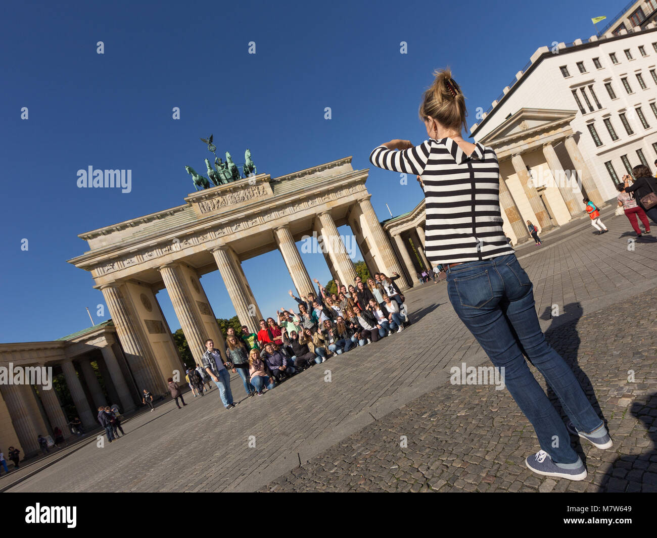 Group Photo Shoot of Tourists in Front of Berlin Brandenburg Gate Stock Photo