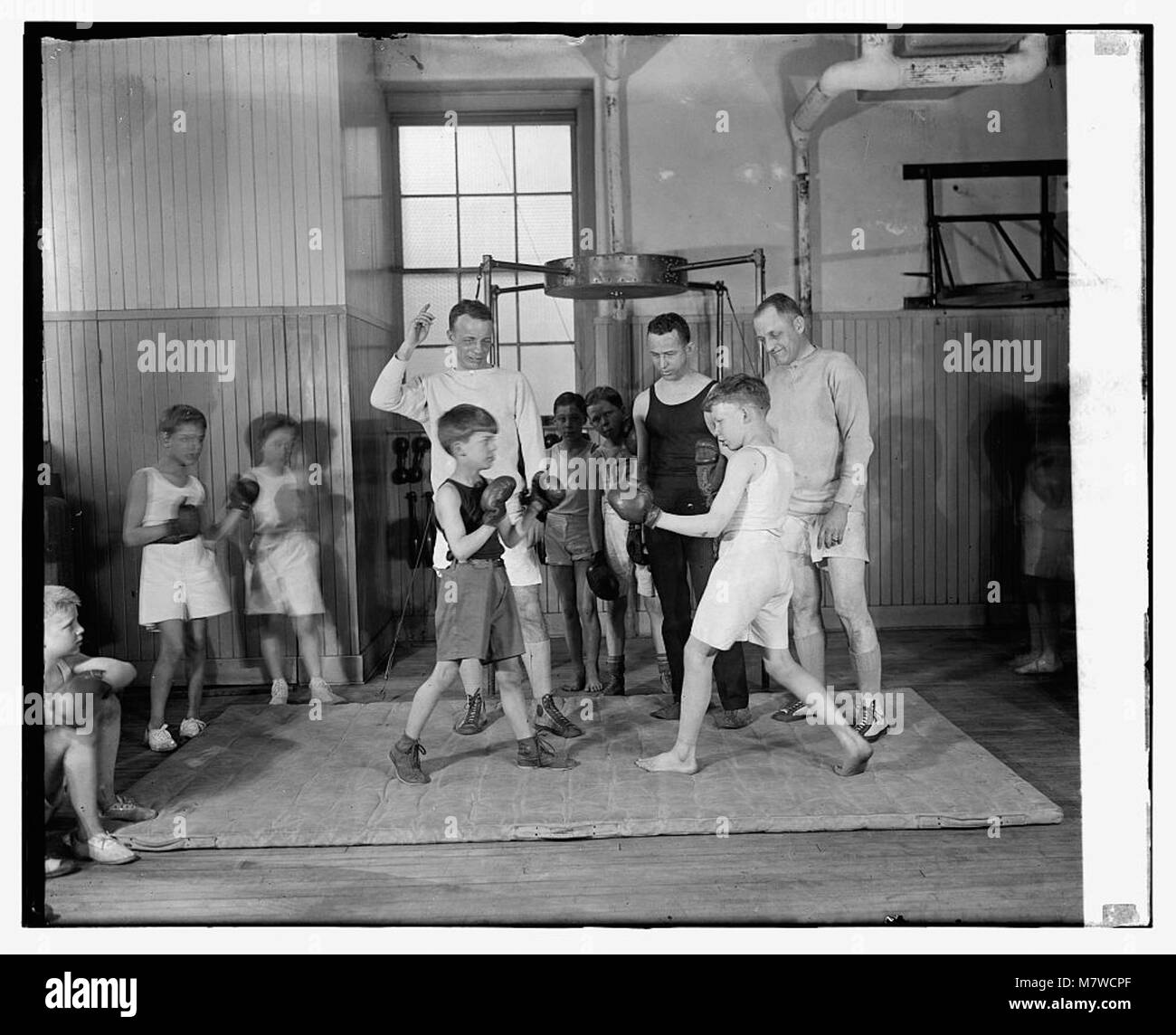 This photograph features Theodore Roosevelt, the 26th President of the United States, engaging in a boxing match on March 22, 1924. Known for his dynamic personality and physical endurance, Roosevelt remained active in sports even in later years, showcasing his robust character. Stock Photo