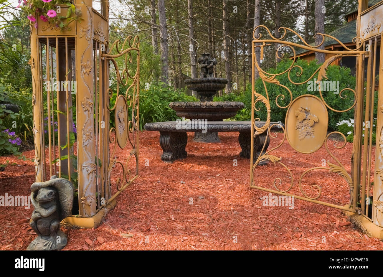 Golden Wrought Iron Metal Arbour Gate Decorated With Pink Petunia Flowers And Cascading Water Fountain In Private Backyard Garden In Summer Stock Photo Alamy