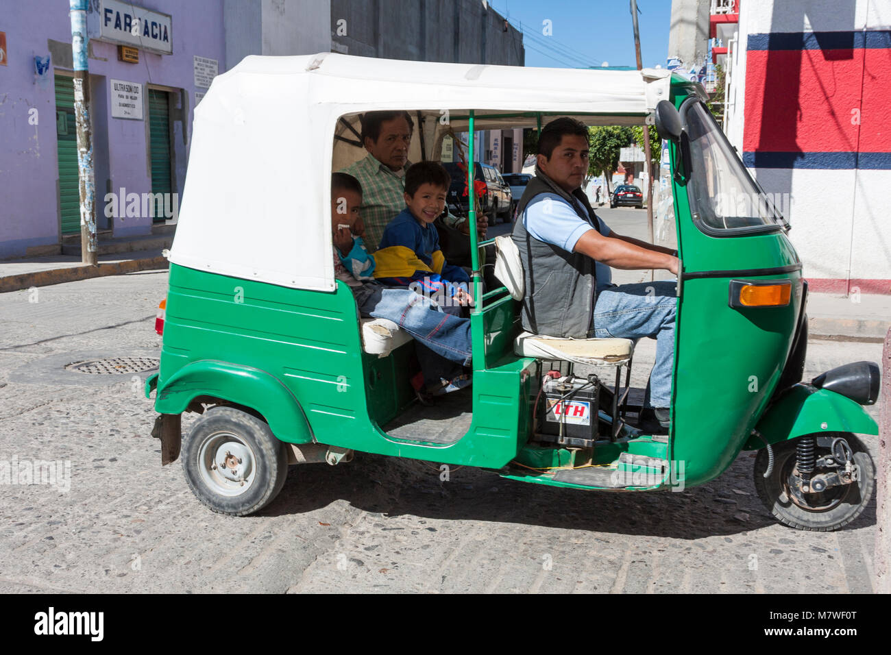 Tlacolula, Oaxaca; Mexico.  Three-wheeled Moto-taxi and Passengers. Stock Photo