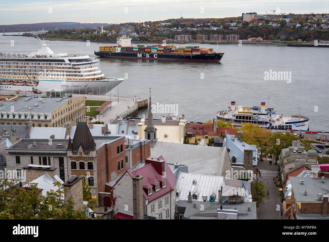 Quebec, Canada.  Ships on the St. Lawrence River.  Crystal Serenity Cruise Ship on left, Container Cargo Ship in Mid-river. Stock Photo