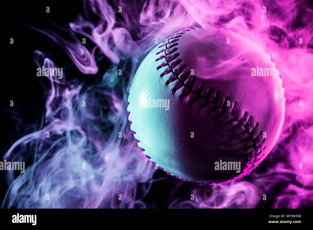 Colorful baseball ball in multi-colored red smoke from a vape on a