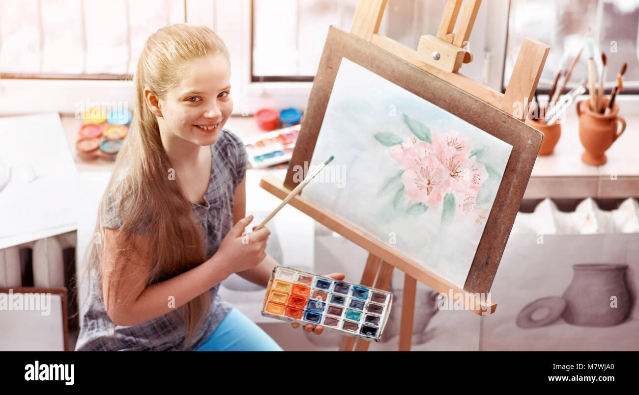 Artist painting on easel in studio. Girl paints with brush Stock Photo ...