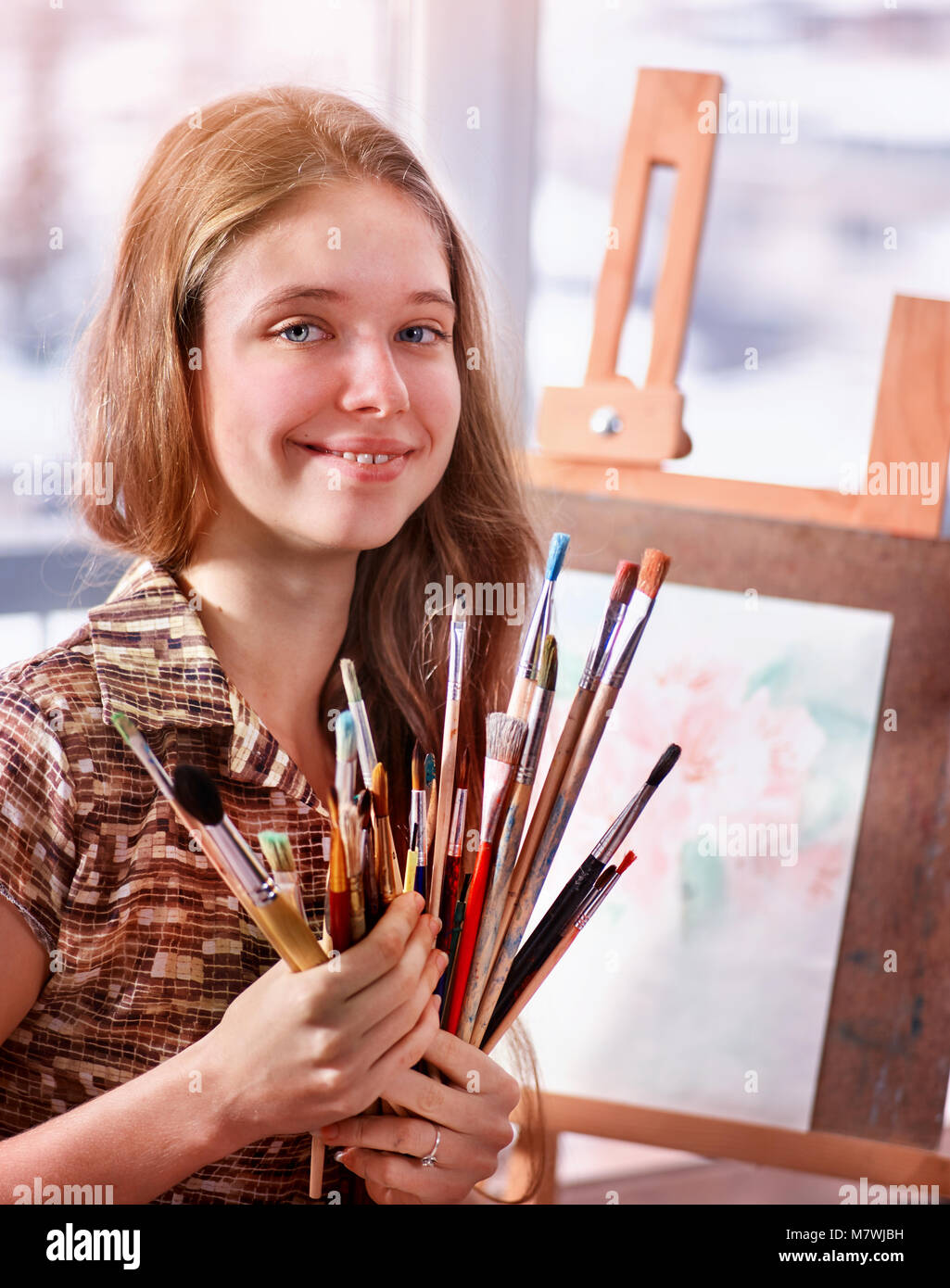 Artist painting on easel in studio. Girl paints with brush Stock Photo ...