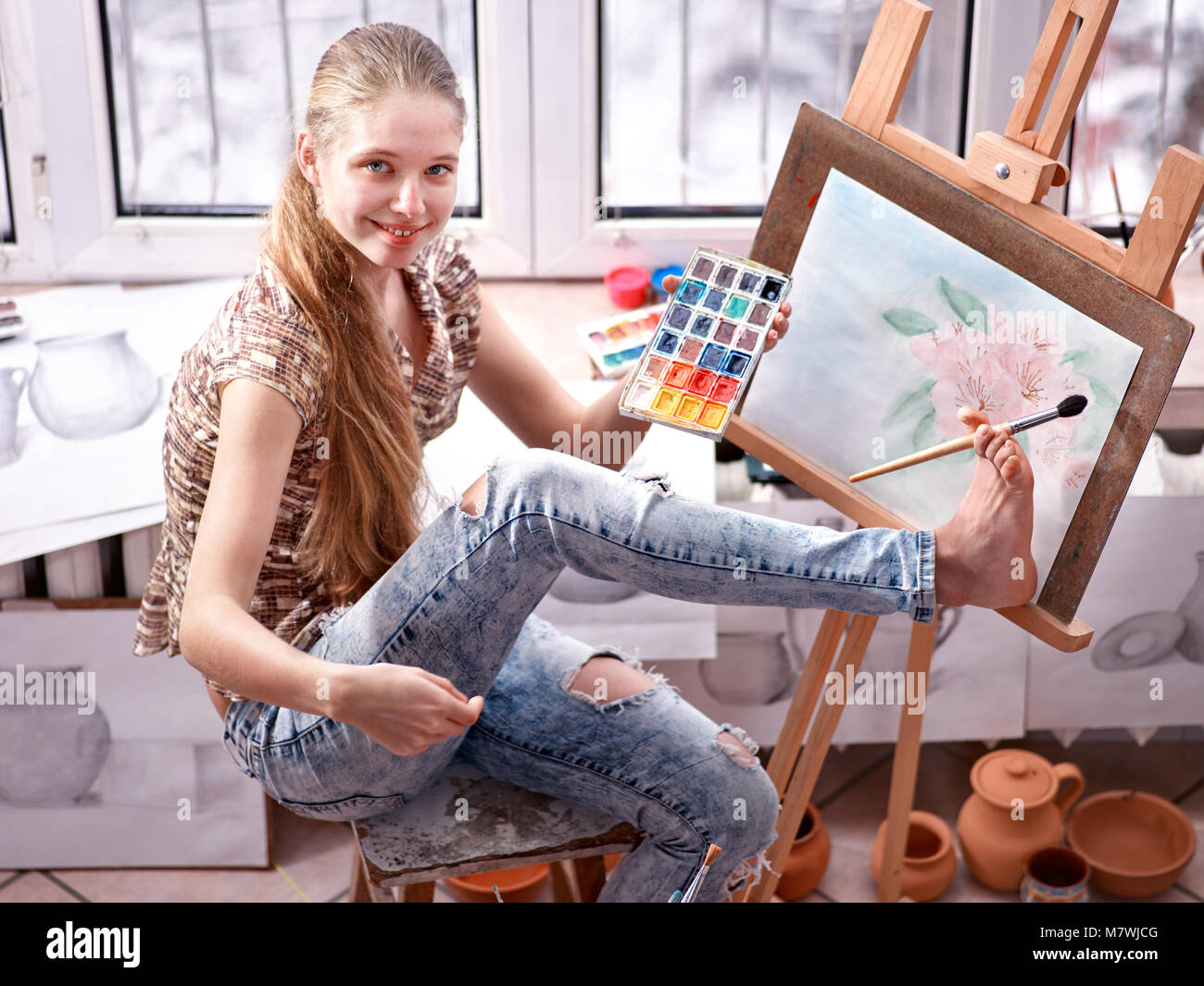 Artist painting on easel in studio. Girl paints with brush Stock Photo ...