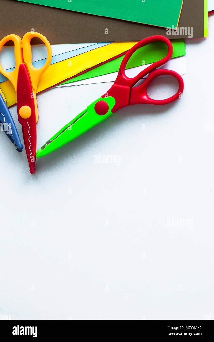 curly scissors and colored sheets of paper for scrapbook classes on a white  table. children's stationery creative tools. Creativity concept Stock Photo  - Alamy