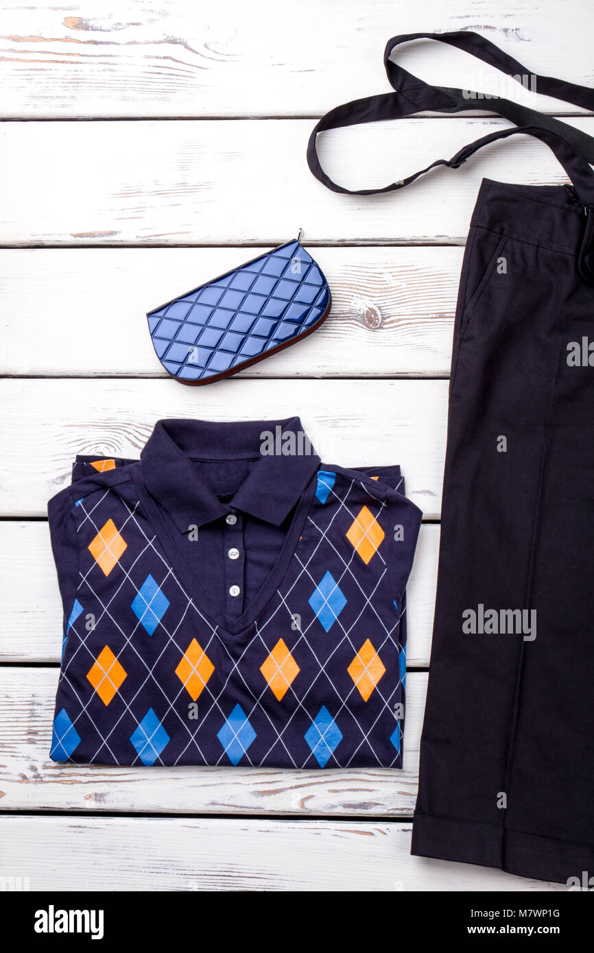 Flat lay decorated polo shirt and blue wallet. White wooden background top view. Stock Photo