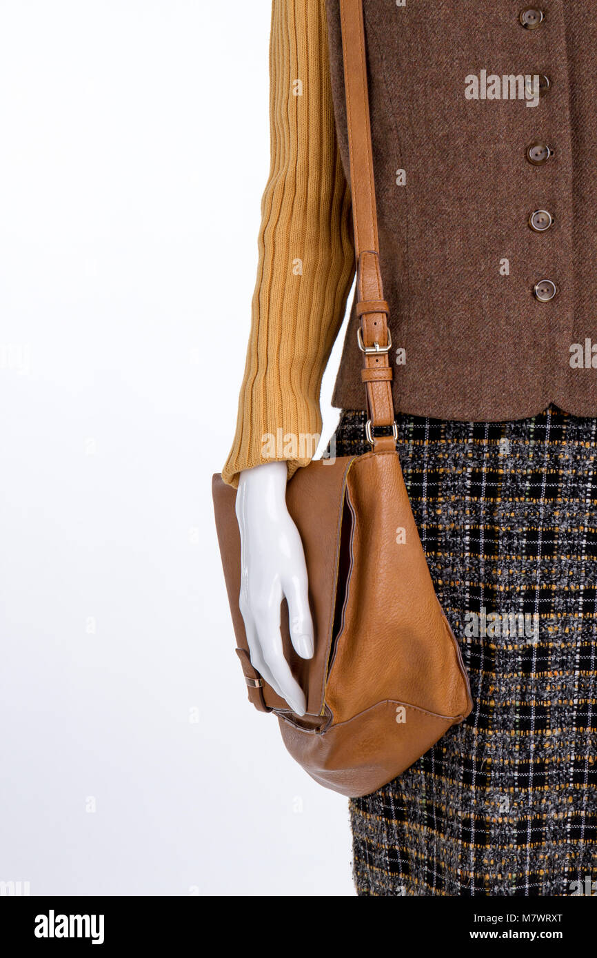 Brown leather purse and womens clothes. Vertical cropped view. White isolated background. Stock Photo