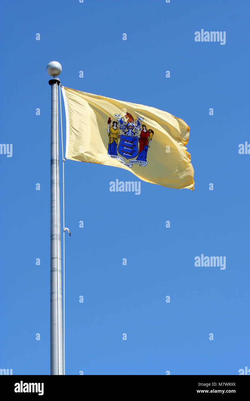 A New Jersey state flag against blue sky Stock Photo