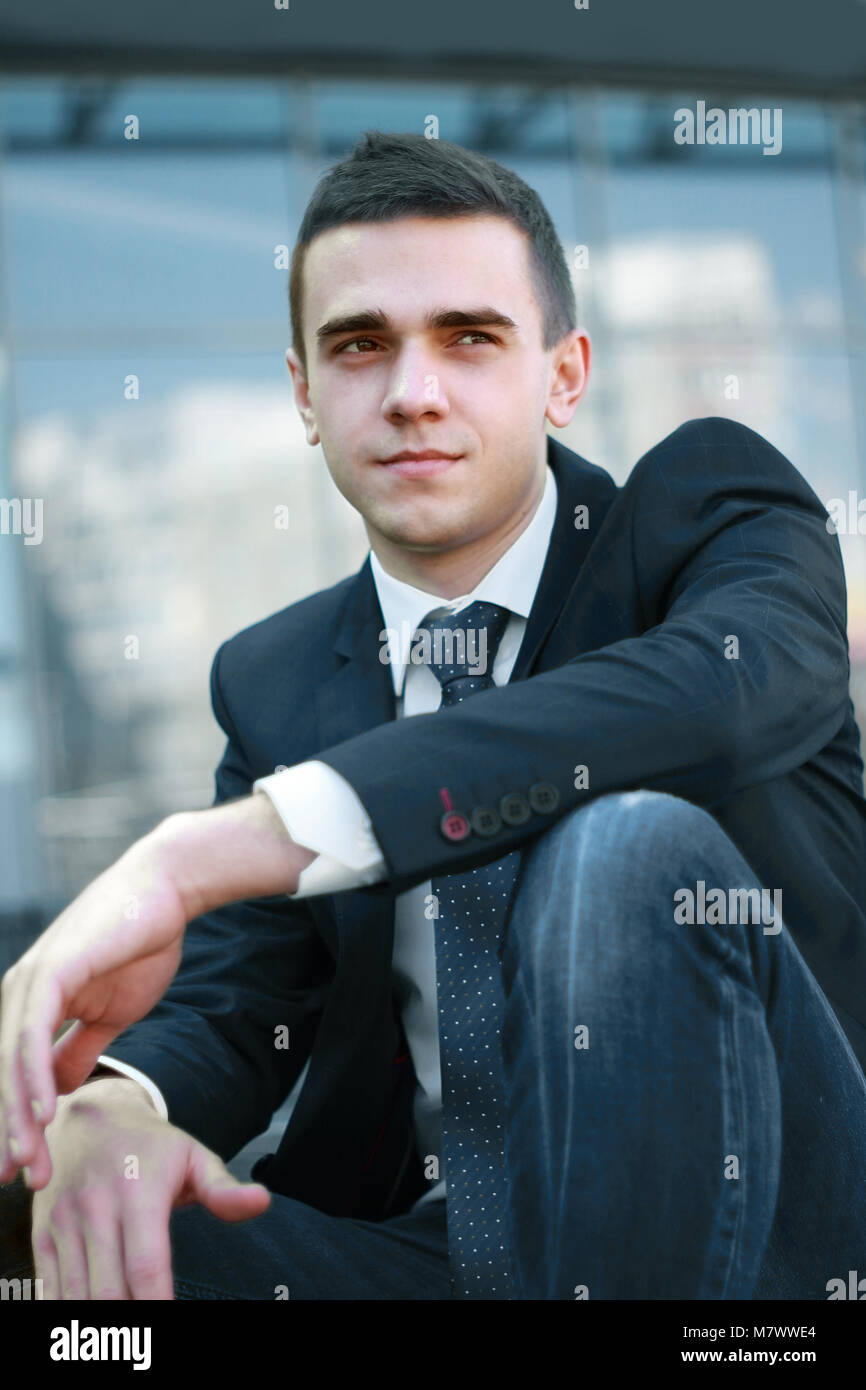 young businessman sitting on the steps of the office Stock Photo