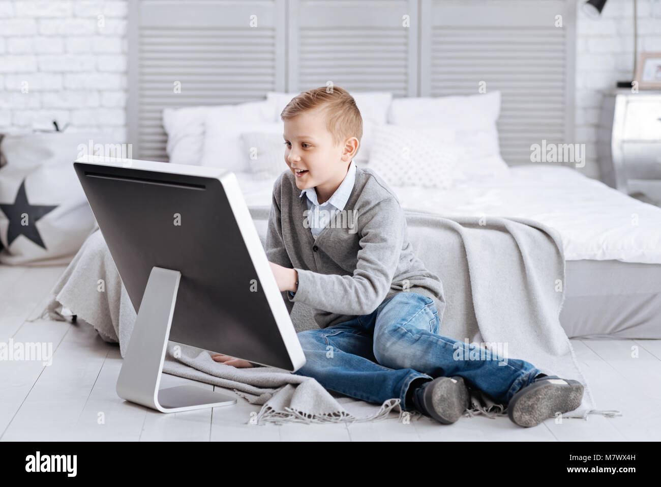 Delighted happy child sitting in front of the screen Stock Photo - Alamy